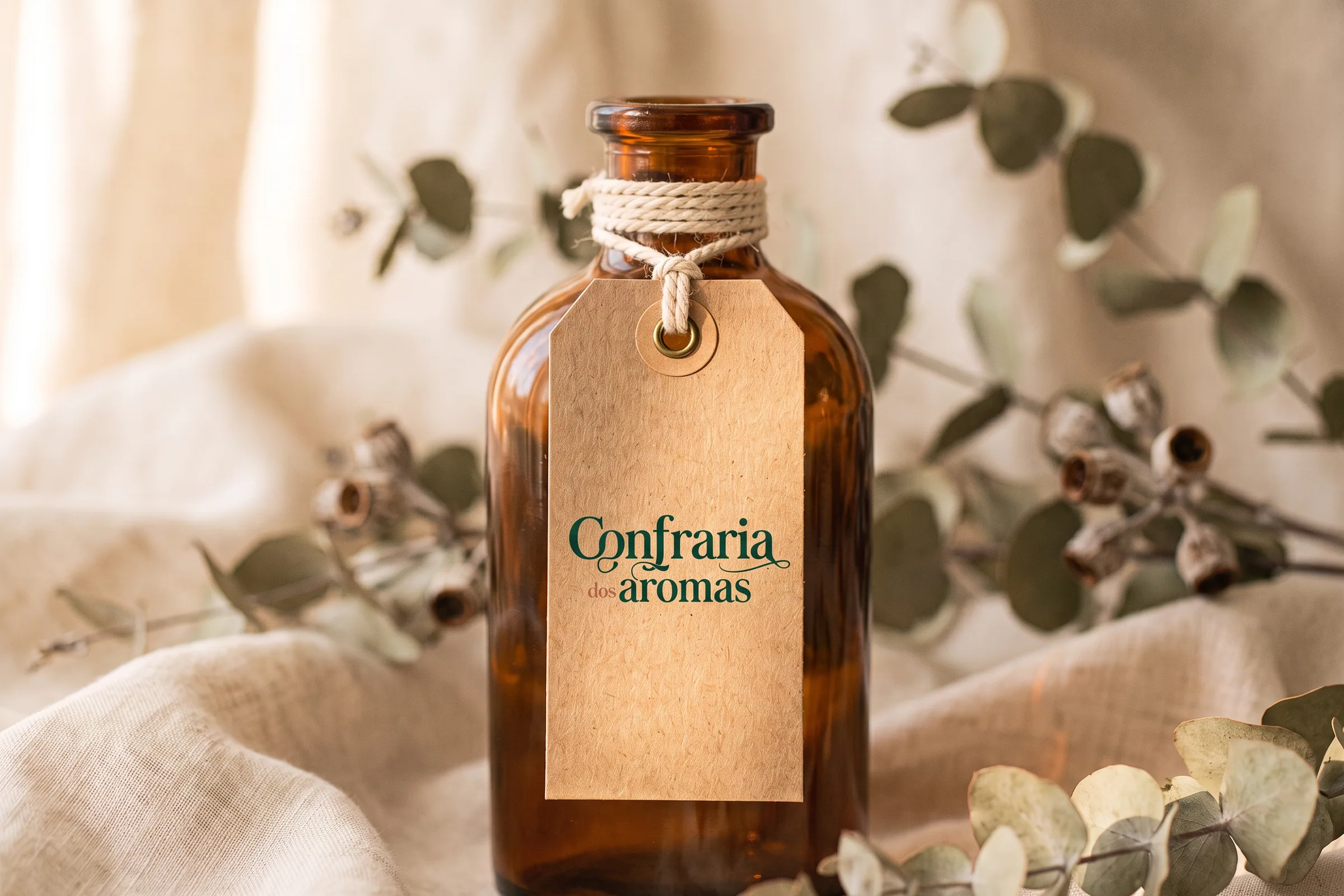 Etiquetas de papel kraft com o monograma da Confraria dos Aromas, presas com barbante