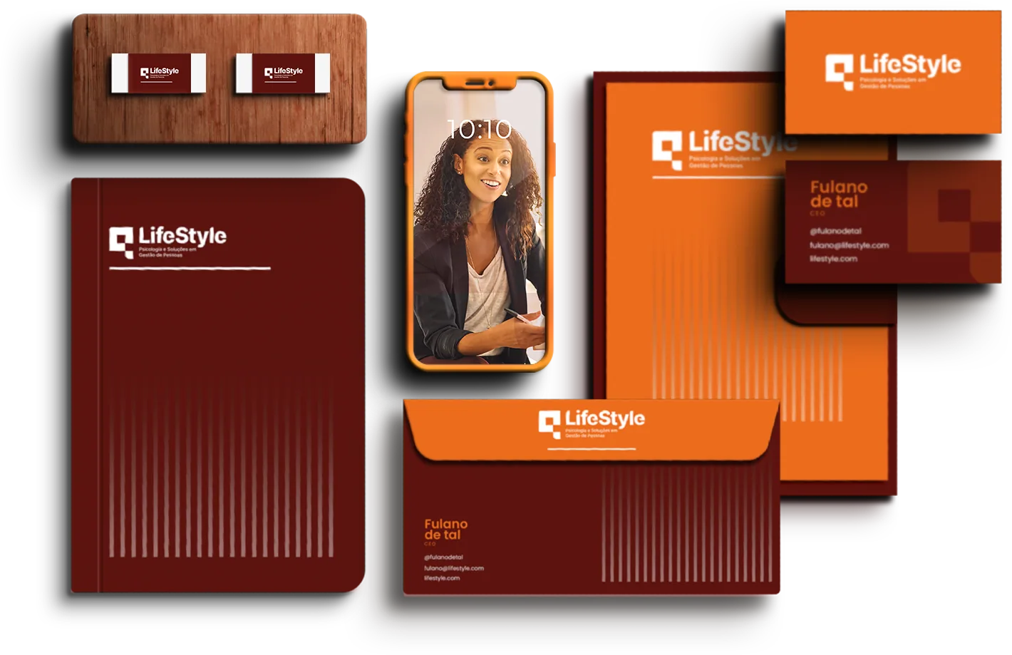 Caderno e envelope bordô, pasta e cartão laranja, cartões de visita e um celular laranja, todos com o logo da LifeStyle em branco